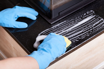Hands in rubber gloves cleaning the fireplace