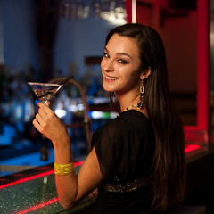 Girl drinks a cocktail in night club