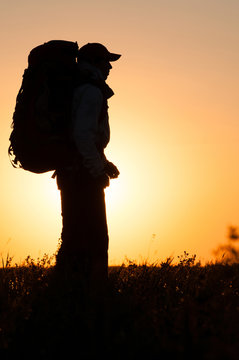 Hiker with backpack standing in the field