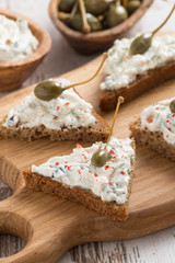 toasts with cheese pate and capers, vertical