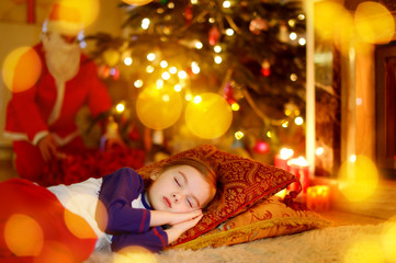 Little girl sleeping under the Christmas tree