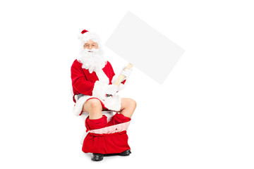 Fototapeta na wymiar Santa seated on toilet and holding a blank banner