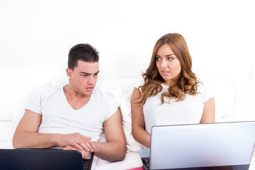 depressed and shocked young man looking at woman's computer