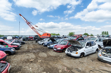 Crane at a car scrapyard moving metal
