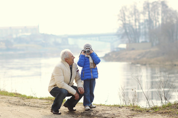 Grandfather and grandson are photographed on a vintage camera