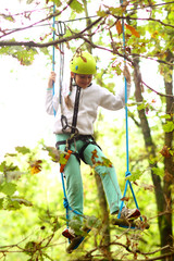 Climber girl child engaged in training between trees