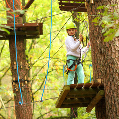 Climber girl child engaged in training between trees