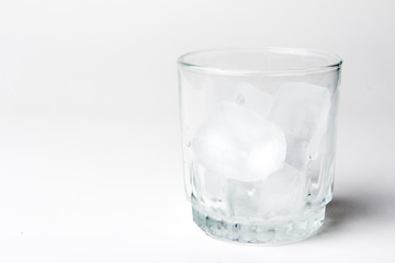 empty glass with ice cubes on white background