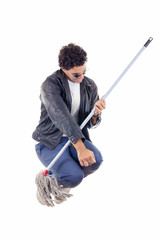  man in leather jacket jumps with a broom