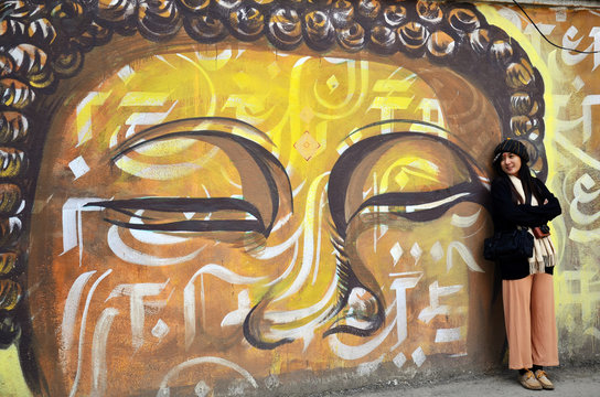 Traveler Thai Women with wall painting on street in Kathmandu