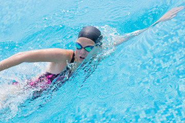 Woman in goggles swimming front crawl style