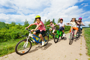 Happy kids riding bikes like in race together