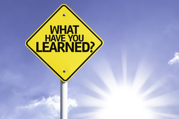 What Have You Learned? road sign with sun background