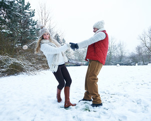 Lachendes Paar tanzt im Schnee