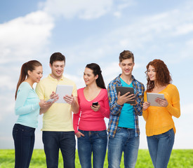 group of teenagers with smartphones and tablet pc