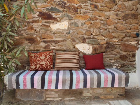 cushions and kelim on a stone bench