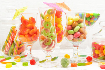 Different colorful fruit candy in glasses