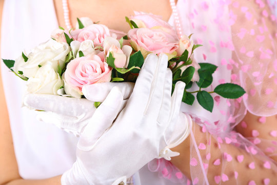 Beautiful bride in white gloves holding wedding bouquet,