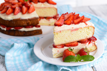 Delicious biscuit cake with strawberries on table close-up