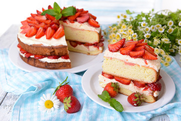 Delicious biscuit cake with strawberries on table close-up