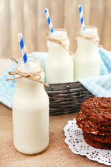 Milk in bottles with paper straws on table