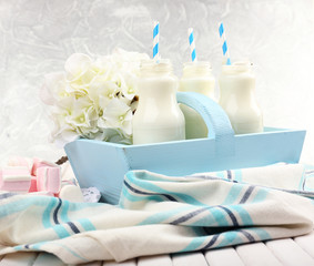 Fototapeta na wymiar Milk in bottles with paper straws on table