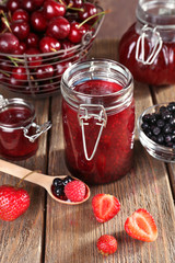 Berries jam in glass jar on table, close-up