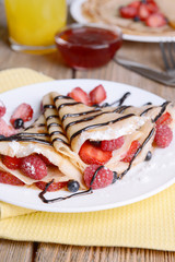 Delicious pancakes with berries on table close-up