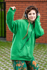 Naklejka premium Teenage girl listening to music in headphones