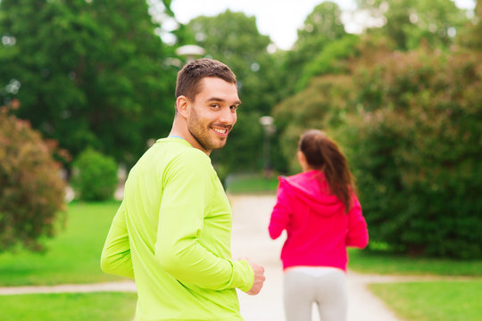 smiling couple running outdoors