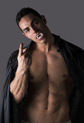 Naklejka na ściany i meble Naked muscular fit young man posing as vampire or Dracula