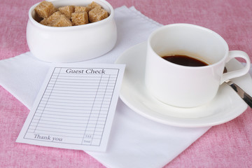 Check and cup of coffee on table close-up