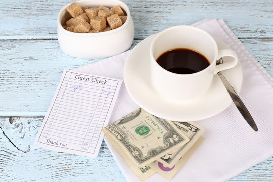 Check, Money And Cup Of Coffee On Table Close-up