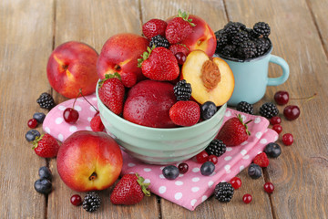 Peaches and berries in bowl on table close-up