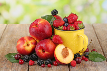 Peaches and berries on table on natural background