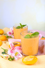 Apricot dessert in glasses on table on bright background