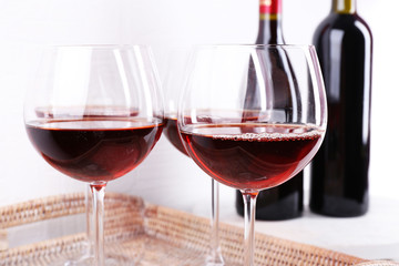 Glasses and wine bottle on tray in room