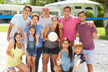 Multi Generation Family Playing Volleyball In Garden