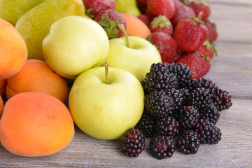 Ripe fruits and berries on wooden background