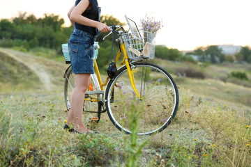 Fototapeta na wymiar Young woman with bicycle in meadow