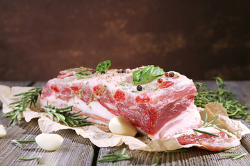 raw bacon with spices on wooden table