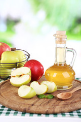 Apple cider vinegar in glass bottle and ripe fresh apples,