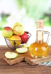 Apple cider vinegar in glass bottle and ripe fresh apples,