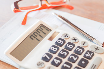 Calculator, pen and on bank account passbook
