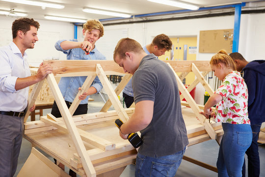 Teacher Helping College Students Studying Carpentry