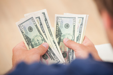 Man Counting Fifty Dollar Bills