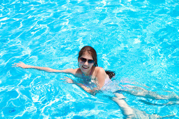 Fototapeta na wymiar Красивая девушка плавает в бассейне