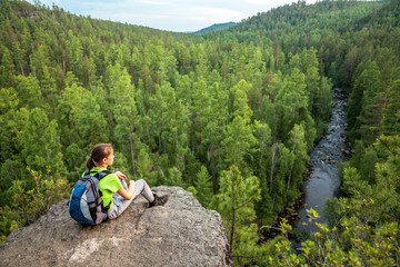 Young backpacker looking into the distance from mountain peak