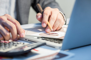 Businessman analyzing investment charts with laptop. Accounting