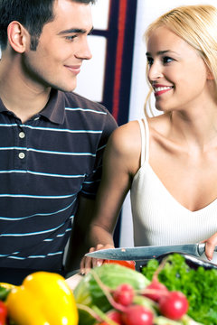 Young attractive happy smiling couple cooking
